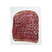 Red pepper salami slice in clear wrapper, with white fat flecks