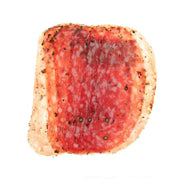 Herb-studded red salami slice with pale outer casing