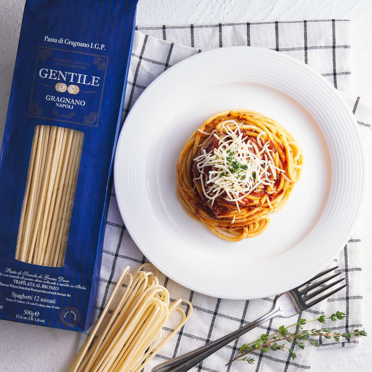 Spaghetti pasta plate with twirled spaghetti and a GENTILE Gragnano IGP bag