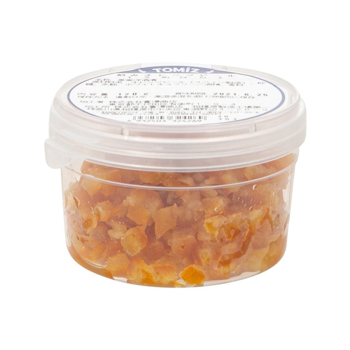 Diced glazed orange peel in plastic tub, orange pieces visible through side