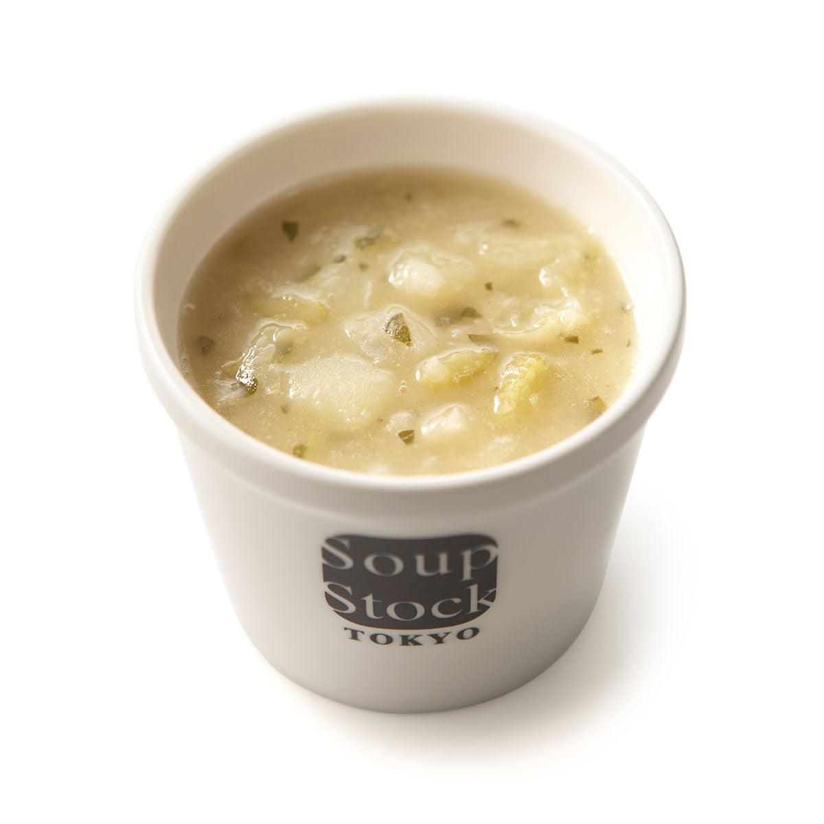 White vegetable minestrone soup in white cup with visible vegetable chunks