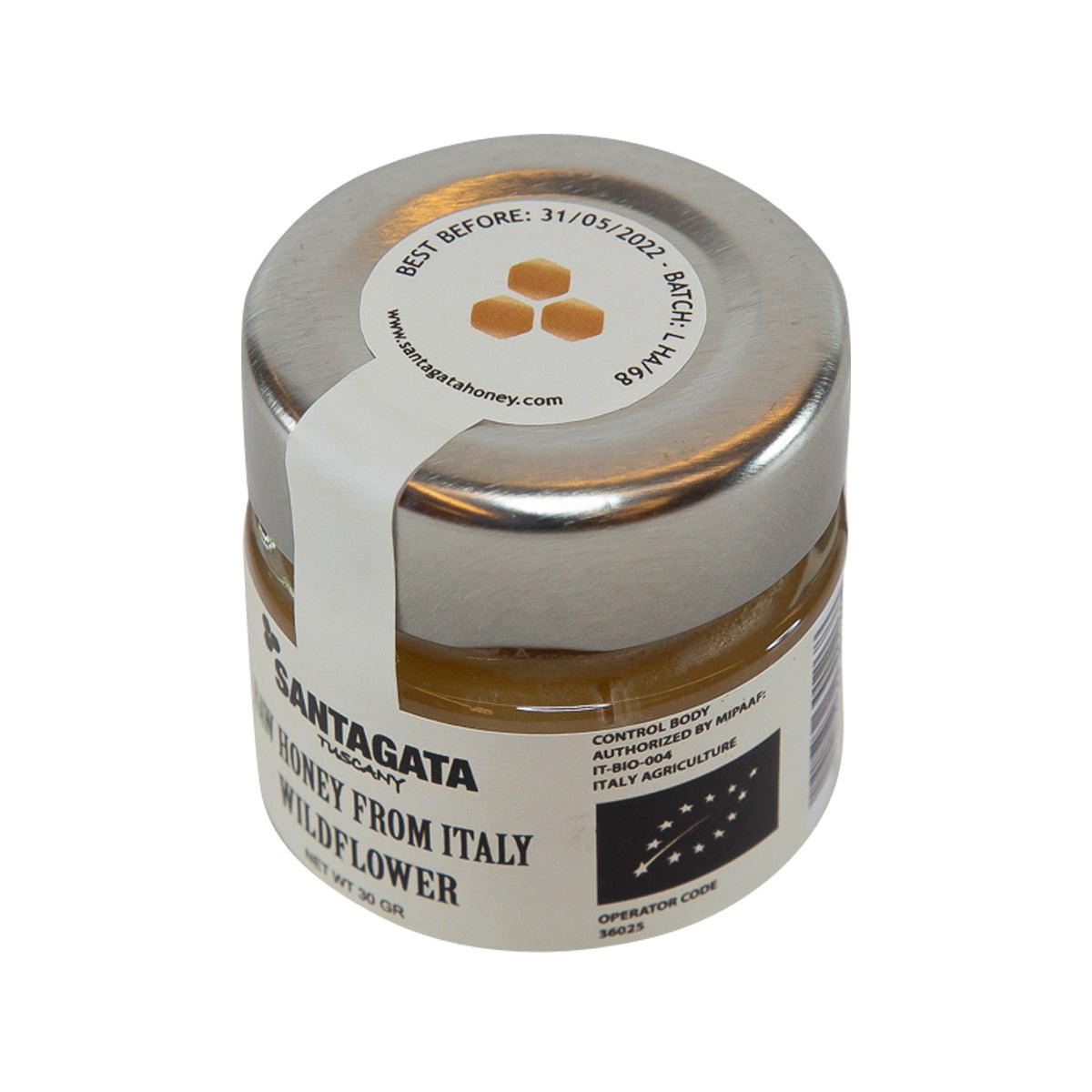 Wildflower raw honey jar, back label visible on small glass bottle with silver cap