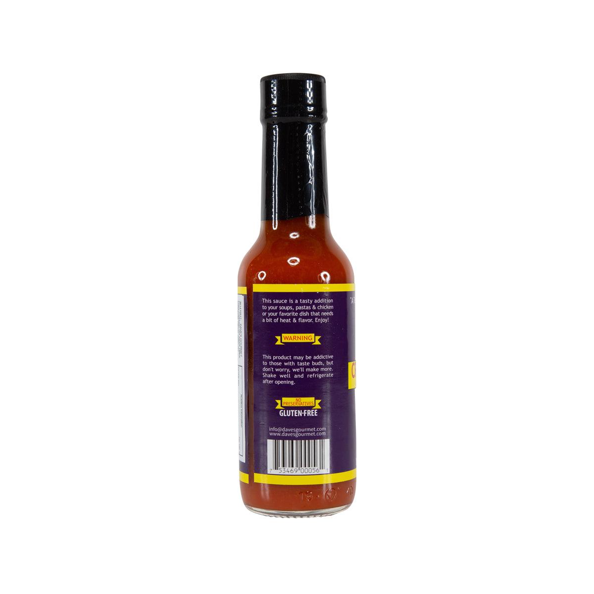 Hot sauce bottle with back label, amber sauce visible through the glass