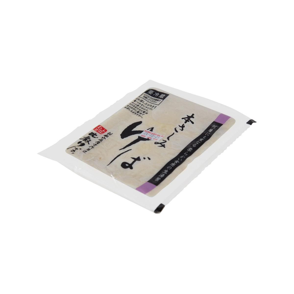 Fresh bean curd skin pouch, sealed packet with beige curd skin shown through plastic