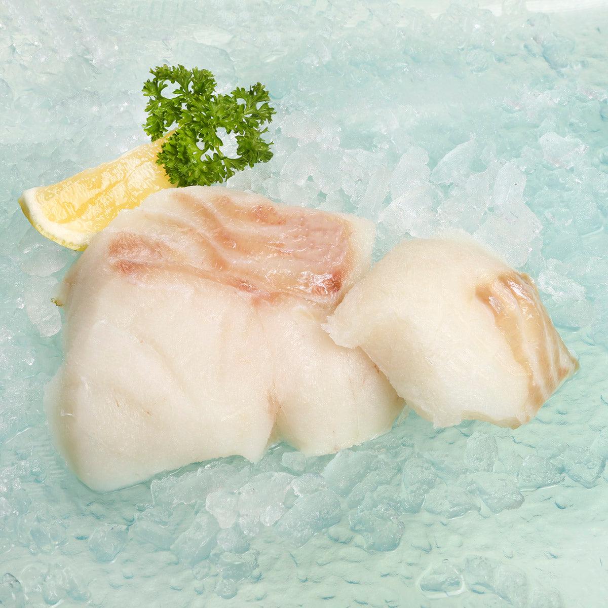 Frozen Alaska cod fillets, pale white fish pieces with parsley garnish