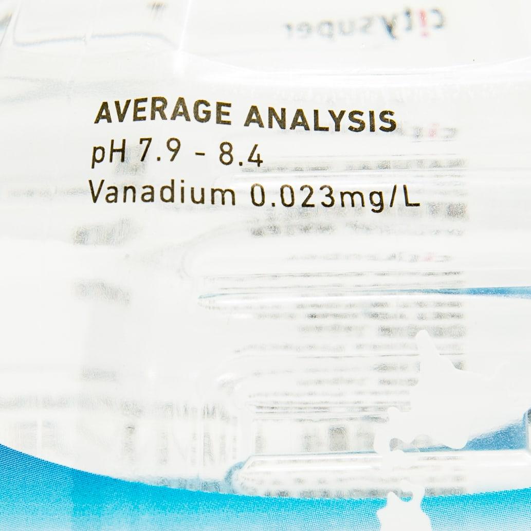 Close-up of natural water label showing average analysis pH 7.9–8.4.