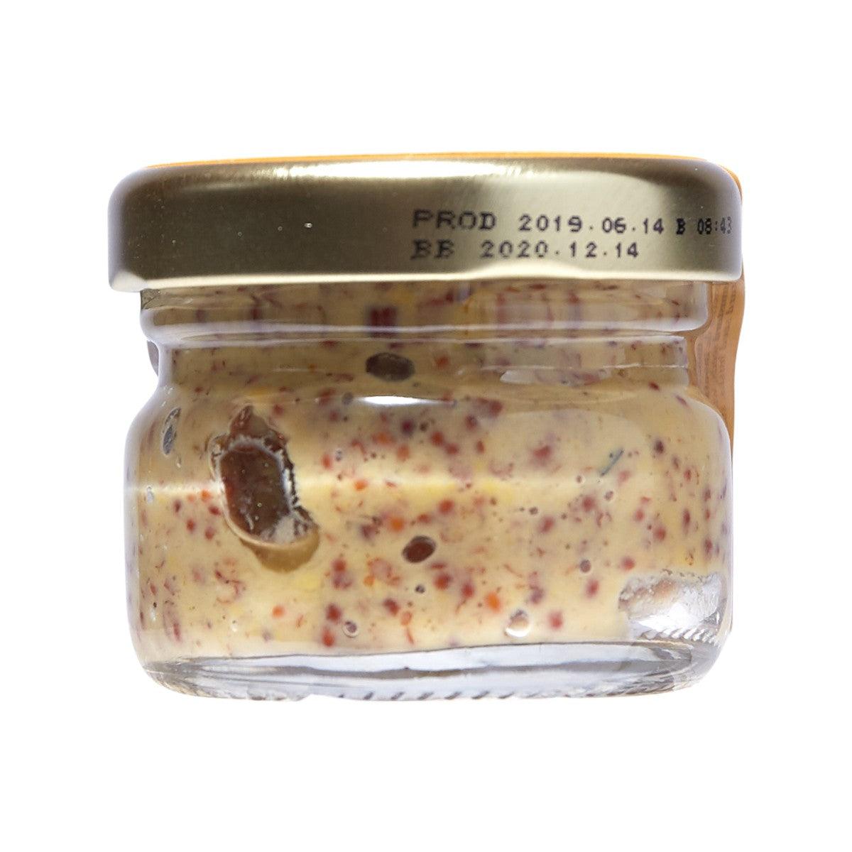 Glass jar of seed mustard with visible mustard grains under clear lid