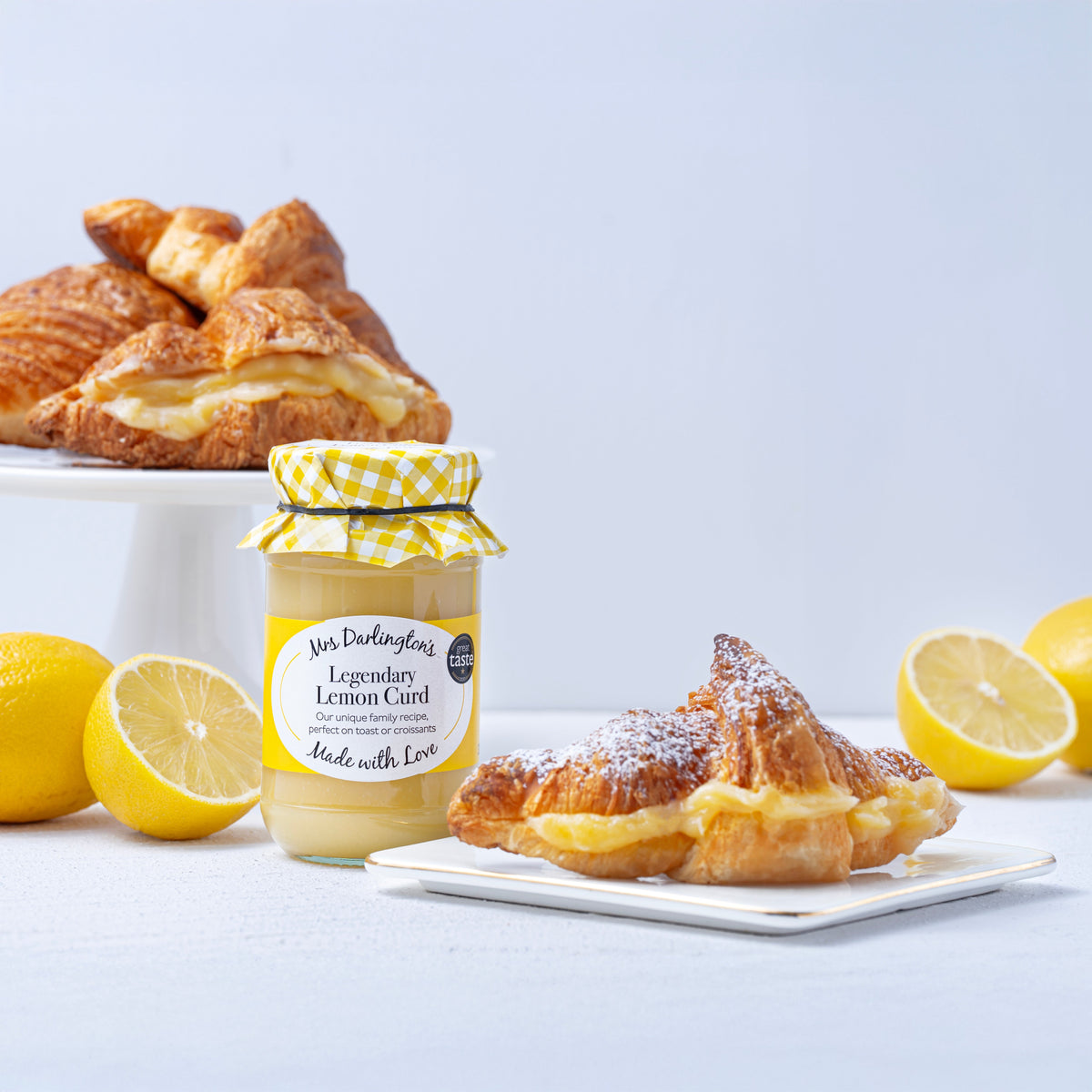 Lemon curd jar with gingham ribbon bow and front label, with pastries and lemons