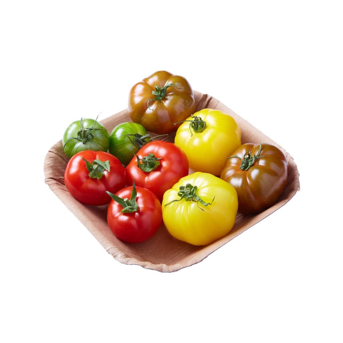 French mixed tomato assortment in wooden bowl: red, yellow, and brown with green stems
