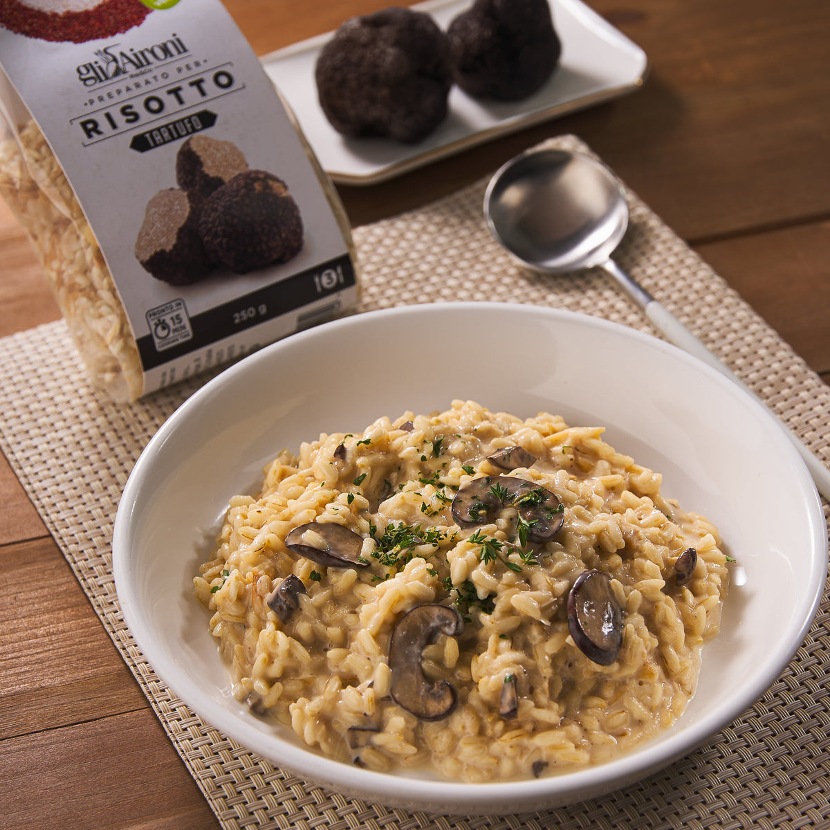 Truffle risotto in white bowl with mushrooms and herbs