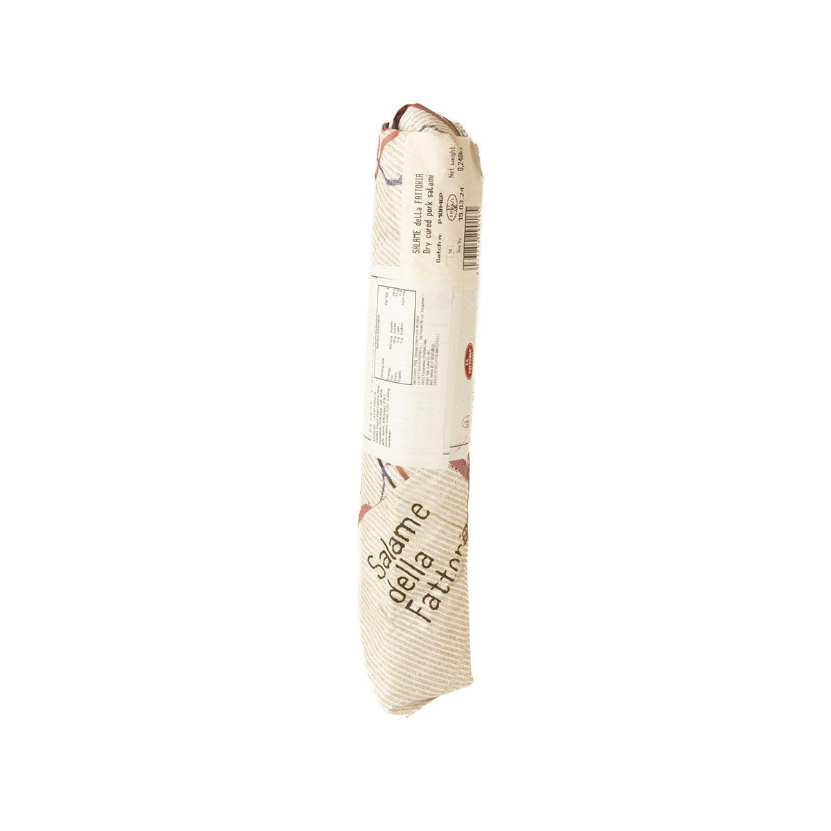 Whole salami wrapped in casing, showing printed packaging text on the back