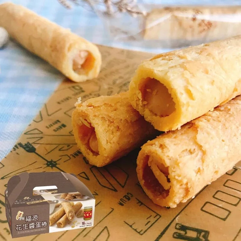 Golden peanut butter egg rolls with cut-open filling on kraft paper, small box