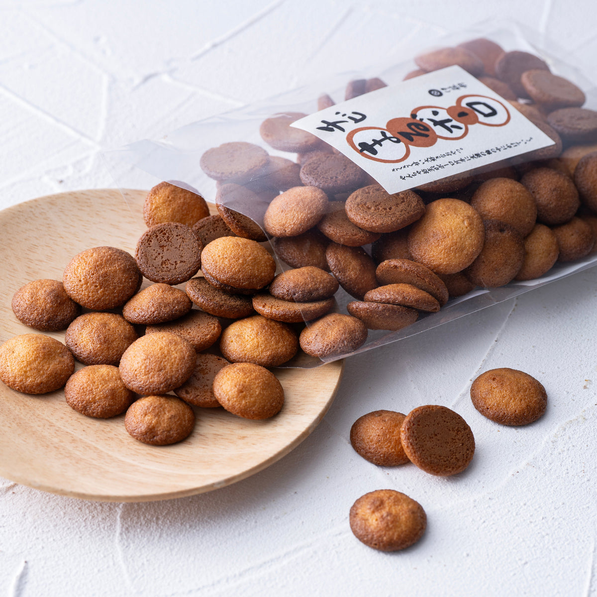 Bolo cookies pile on wooden scoop with label, small round brown cookies
