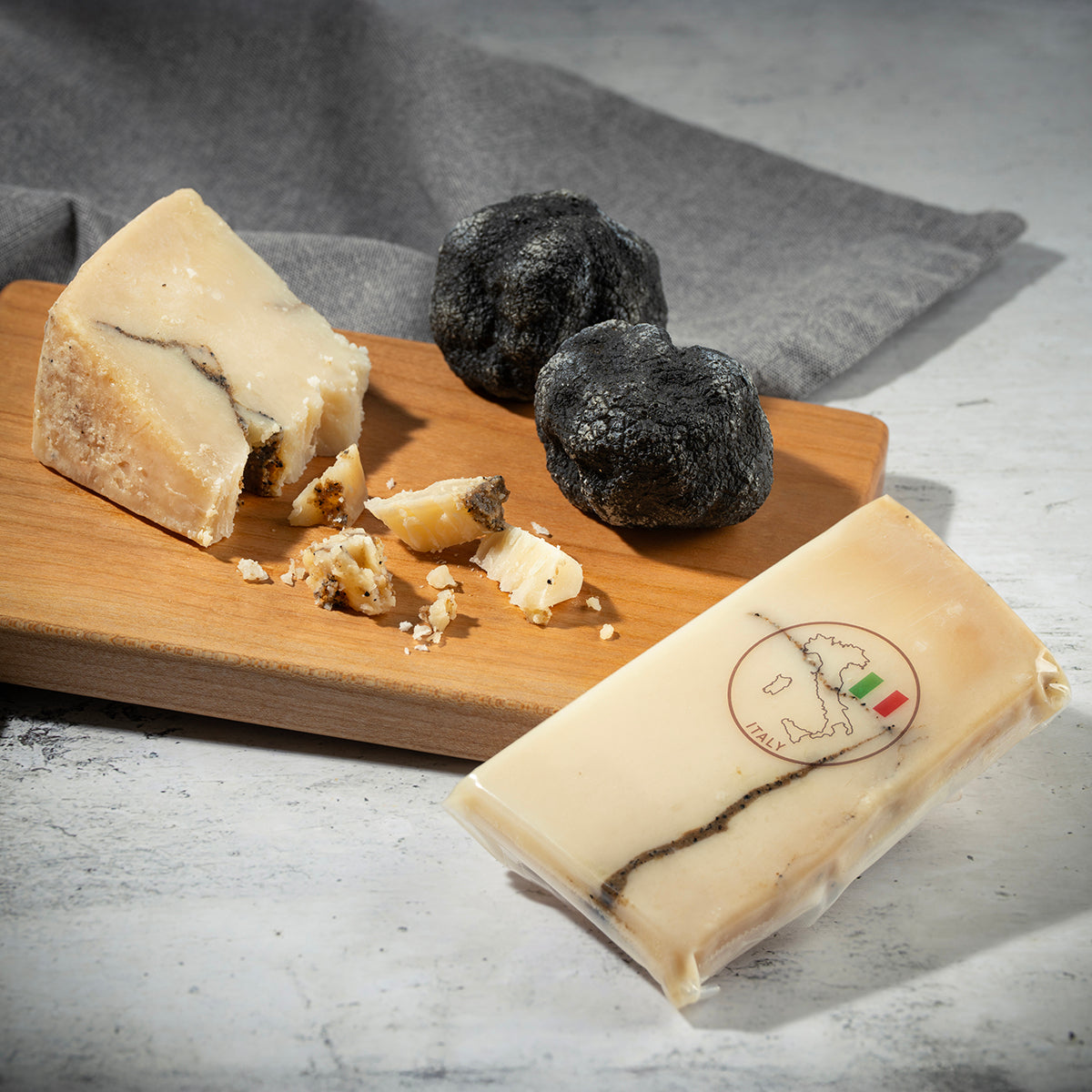 Sheep's milk truffle cheese wedges with black truffles and a wrapped cheese portion