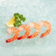 Cooked black tiger prawns, tail-on, peeled, orange-pink shrimp pile