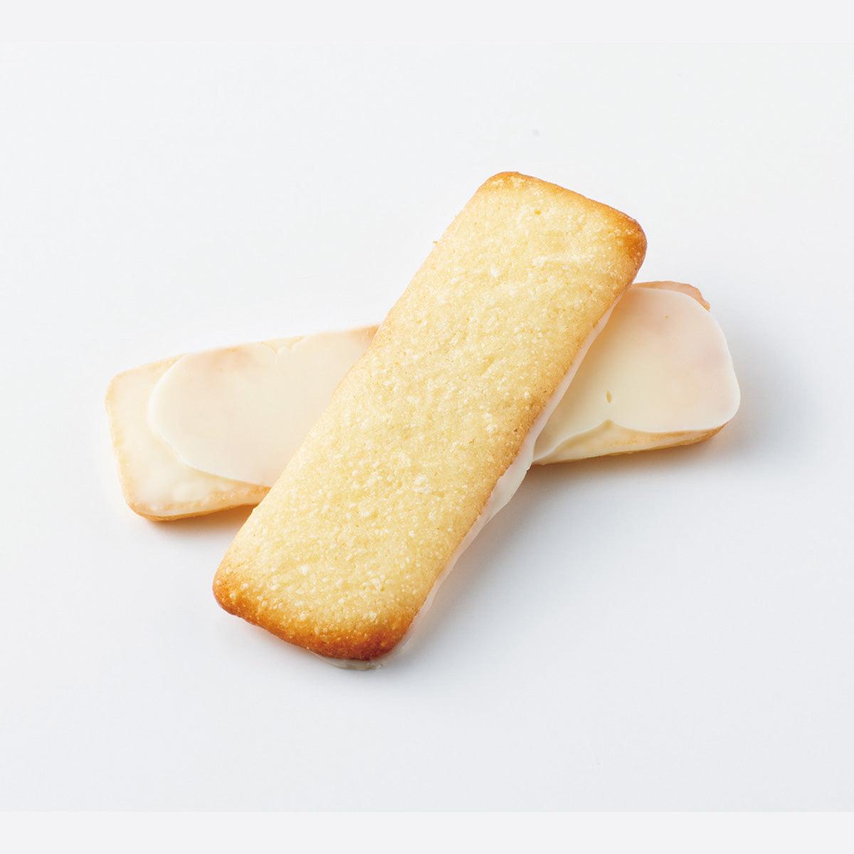 Two long pale baton cookies with cream-colored coating and browned edges
