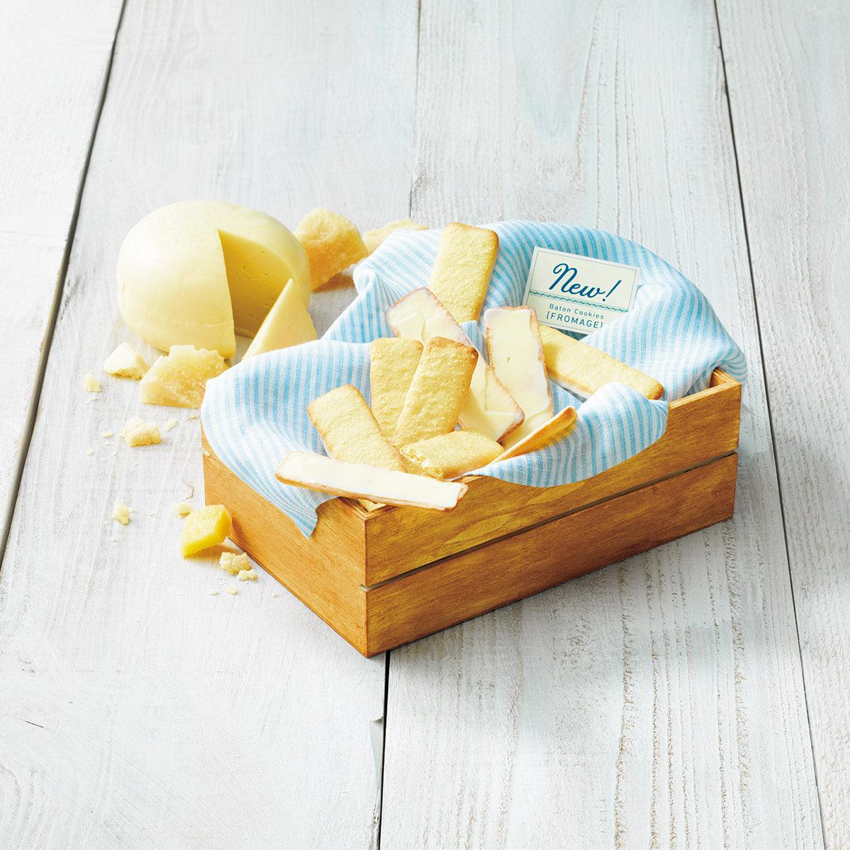 Wood tray filled with pale yellow baton cookies, crumbled pieces scattered