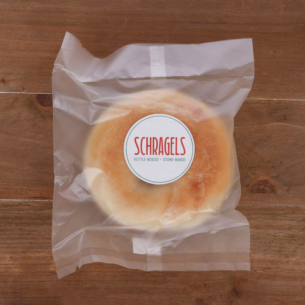 SCHRAGELS plain bagel in open white paper wrap with round brand label