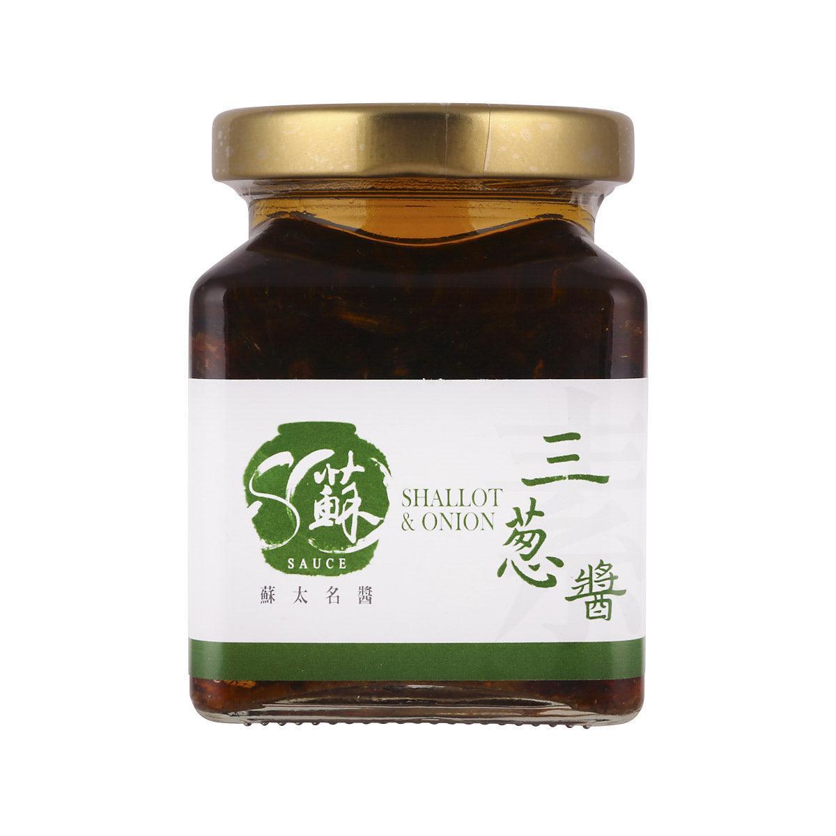 Jar of shallot and onion sauce with dark amber contents and gold lid.