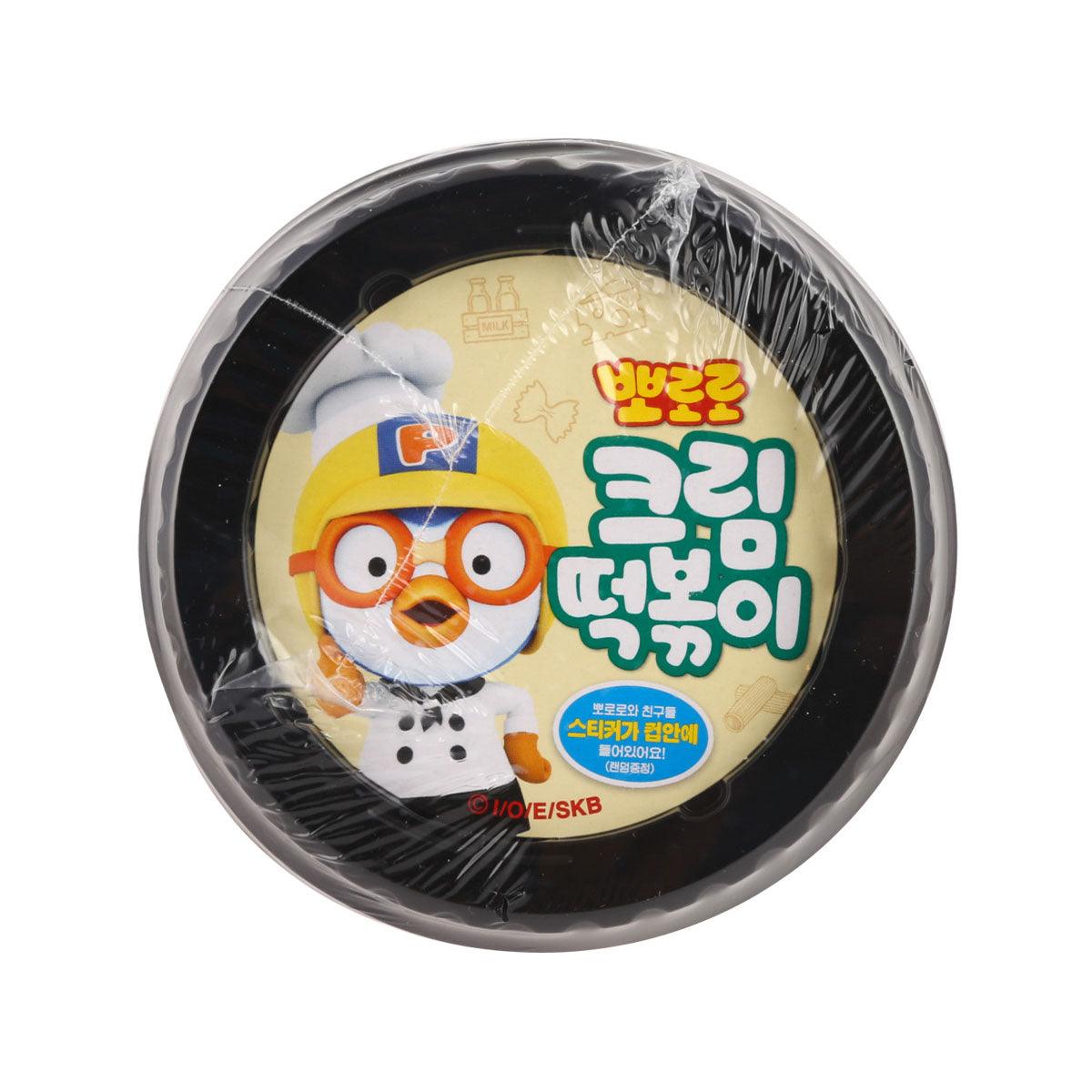 Closed cream tteokbokki cup lid with character graphic under black plastic wrap