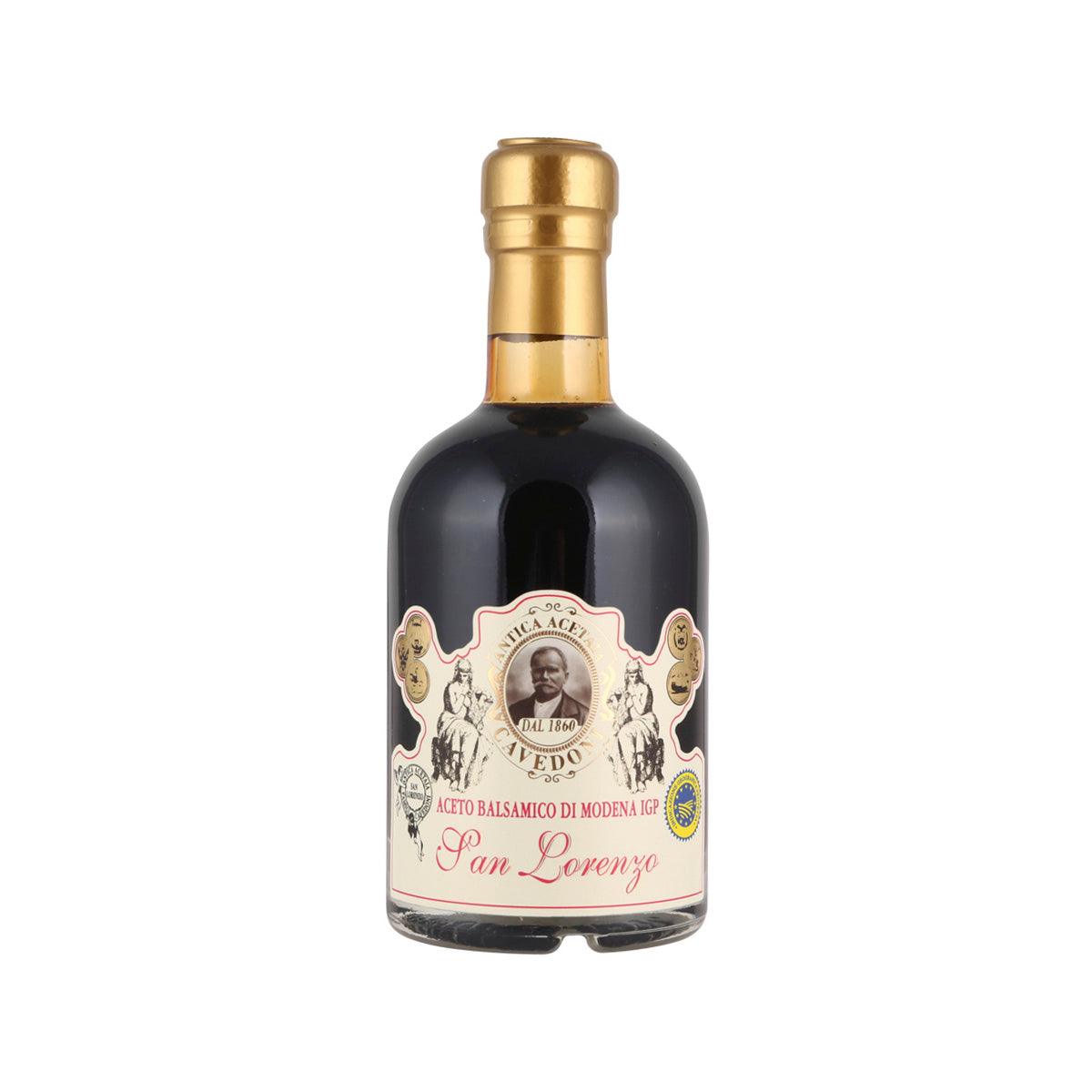 Balsamic vinegar bottle with gold cap and dark glass, front label with ornate badge