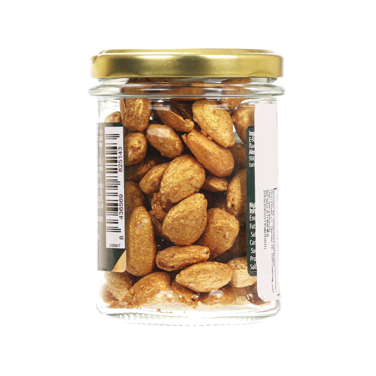 Glass jar of gold almonds with a gold lid, filled with whole nuts