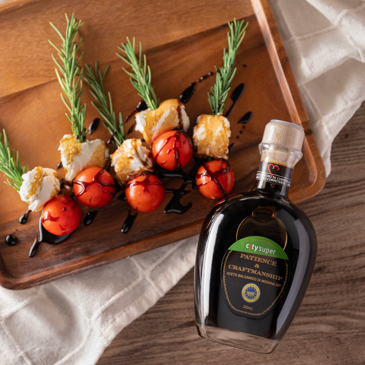 CITYSUPER balsamic vinegar bottle beside food skewers, dark glass with green label