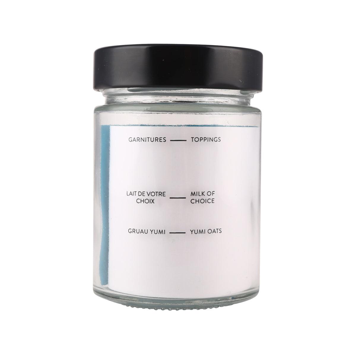 Glass jar with black lid, back label lists toppings and milk of choice