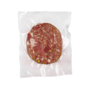 Pig head sausage slice in vacuum-sealed bag, red cured meat with visible fat pieces