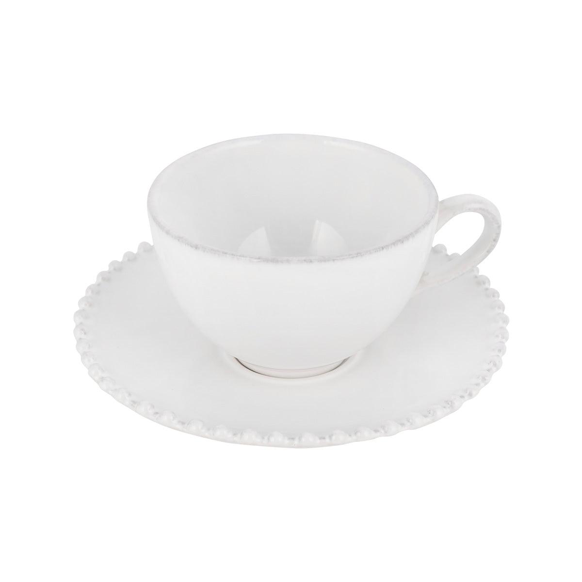White tea cup and saucer set with scalloped edge, side view