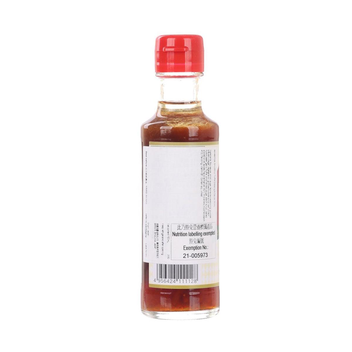Truffle dressing sauce bottle, red cap, clear glass with amber liquid, back label