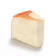 Cow's milk cheese wedge with pale yellow interior and orange rind
