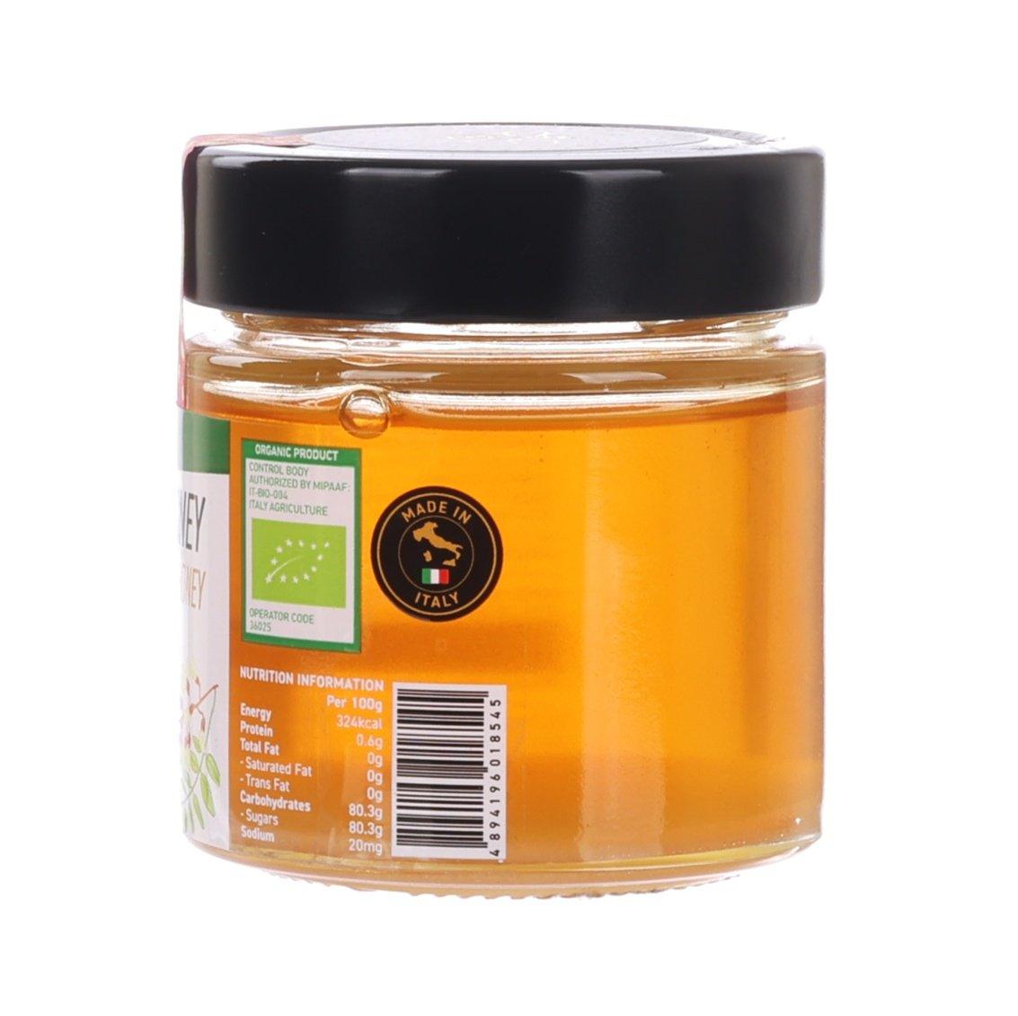 Organic raw honey jar with black lid, amber honey, nutrition label visible