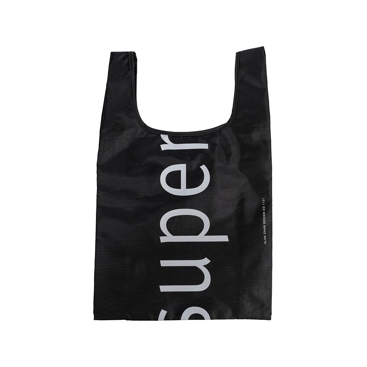 Black pocket tote bag with large CITYSUPER logo print, short handles