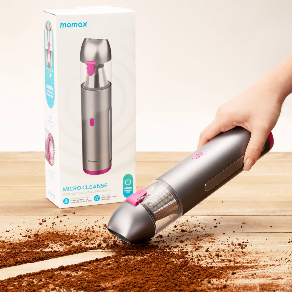 Handheld cordless vacuum cleaner with wide nozzle, silver body, held in hand on floor