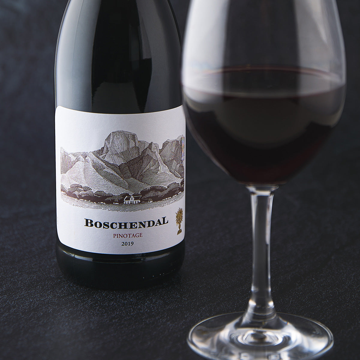 Wine bottle label close-up with BOSCHENDAL text beside a glass of red wine