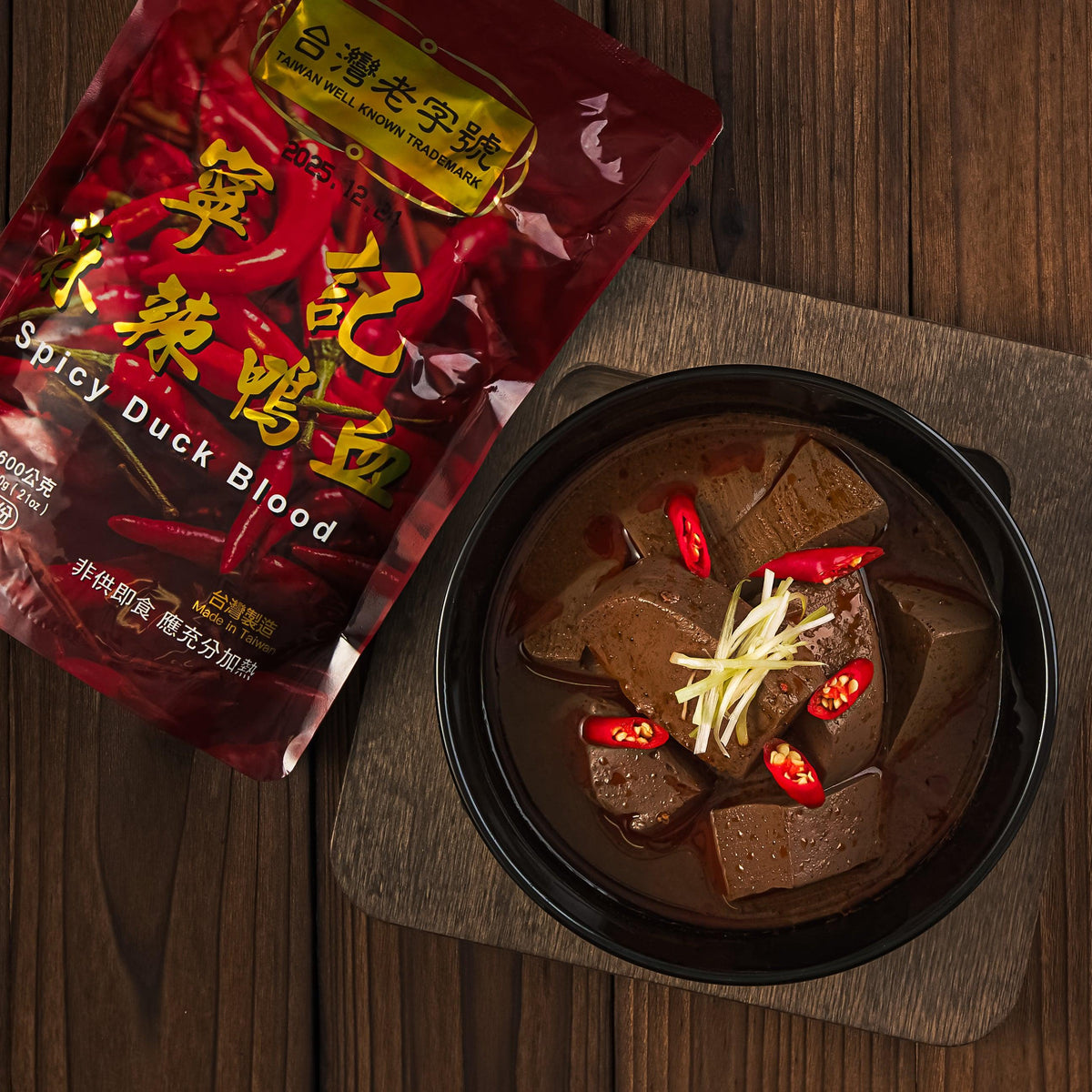 Spicy duck blood bowl with cubed meat, chili pieces, and red seasoning pouch
