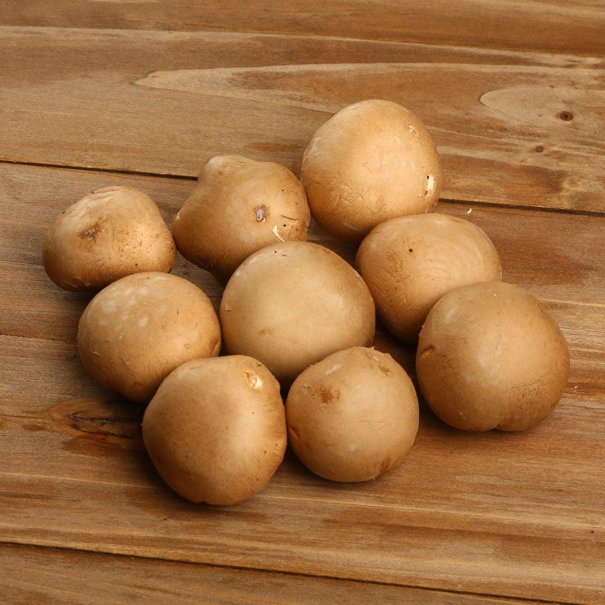 Crimini mushrooms on wooden board, whole