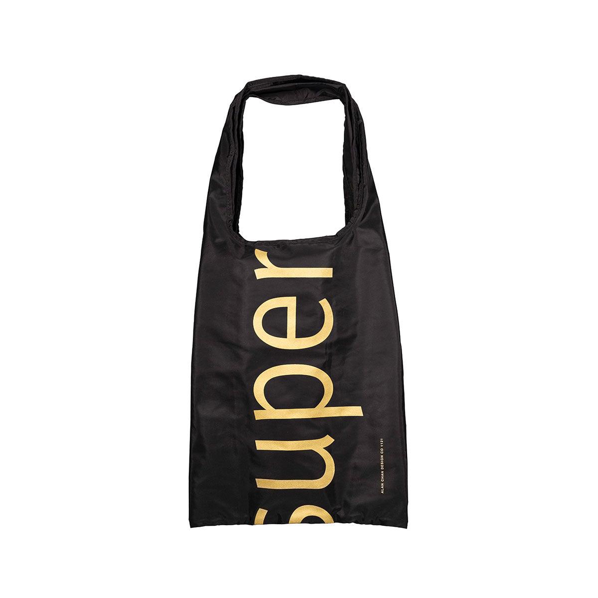 Black pocketable shoulder bag with gold lettering and small side text