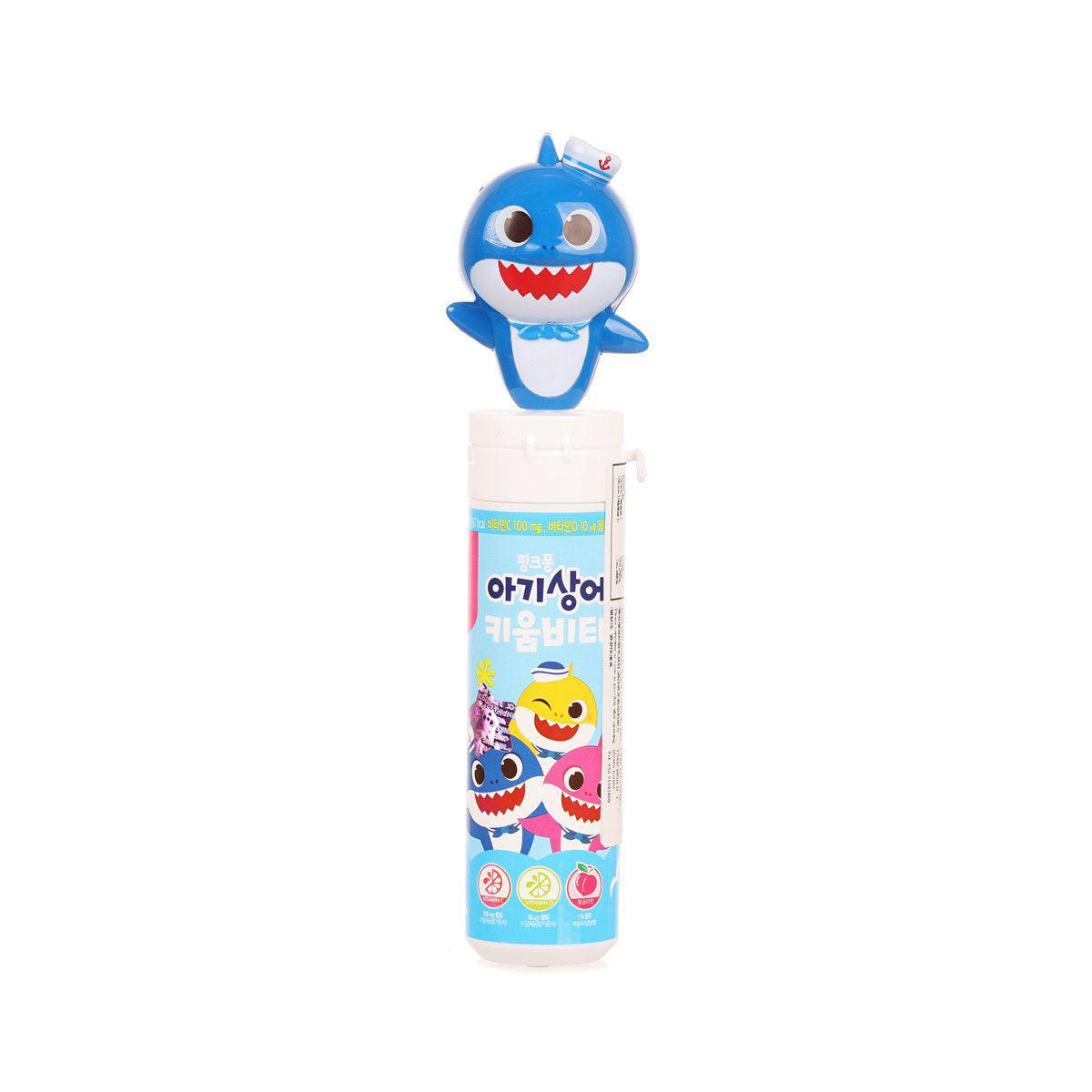 Peach candy tube with blue shark toy topper, cartoon graphic label