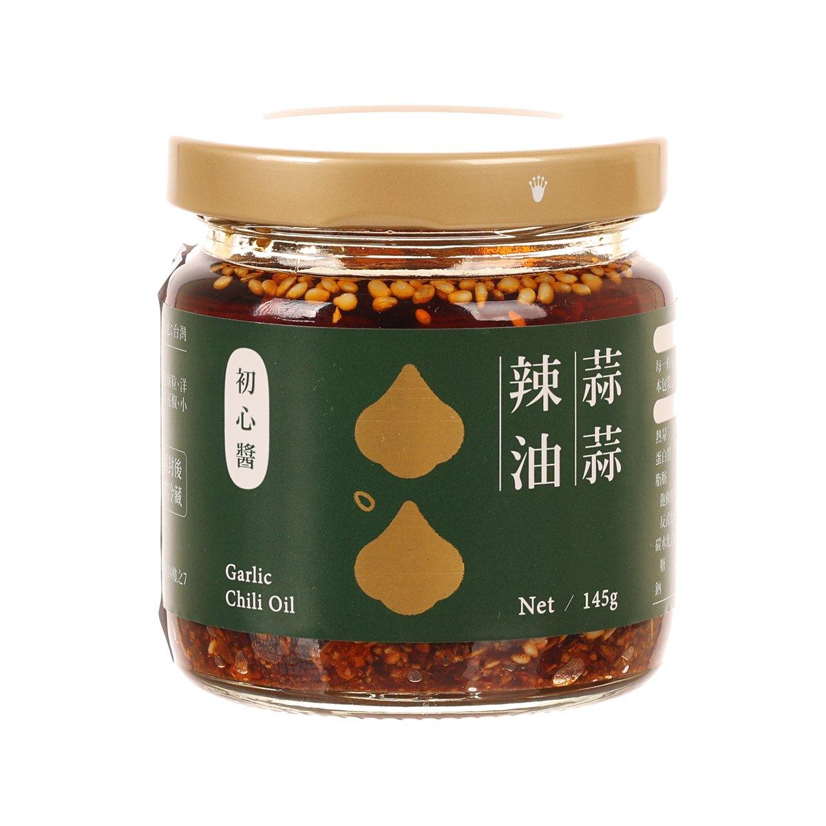Garlic chili oil jar with beige lid; dark red chili flakes and garlic pieces visible.