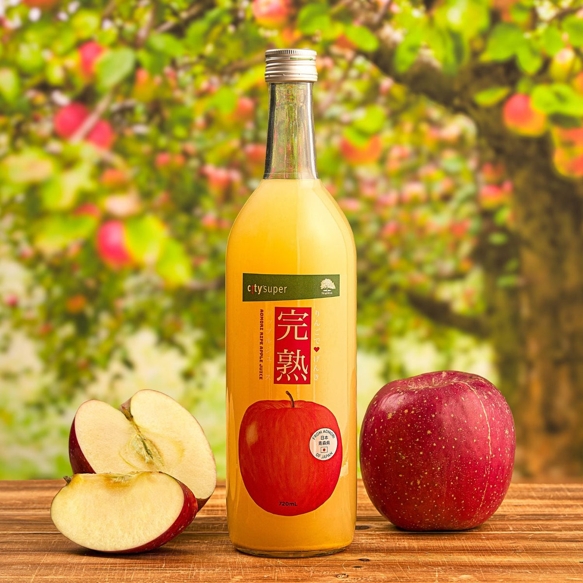 Apple juice bottle with amber liquid and red apple label, with apple halves and whole apple