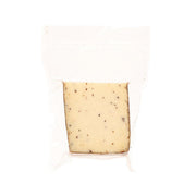 Perlagrigia truffles cheese wedge in white packaging, pale yellow with dark specks