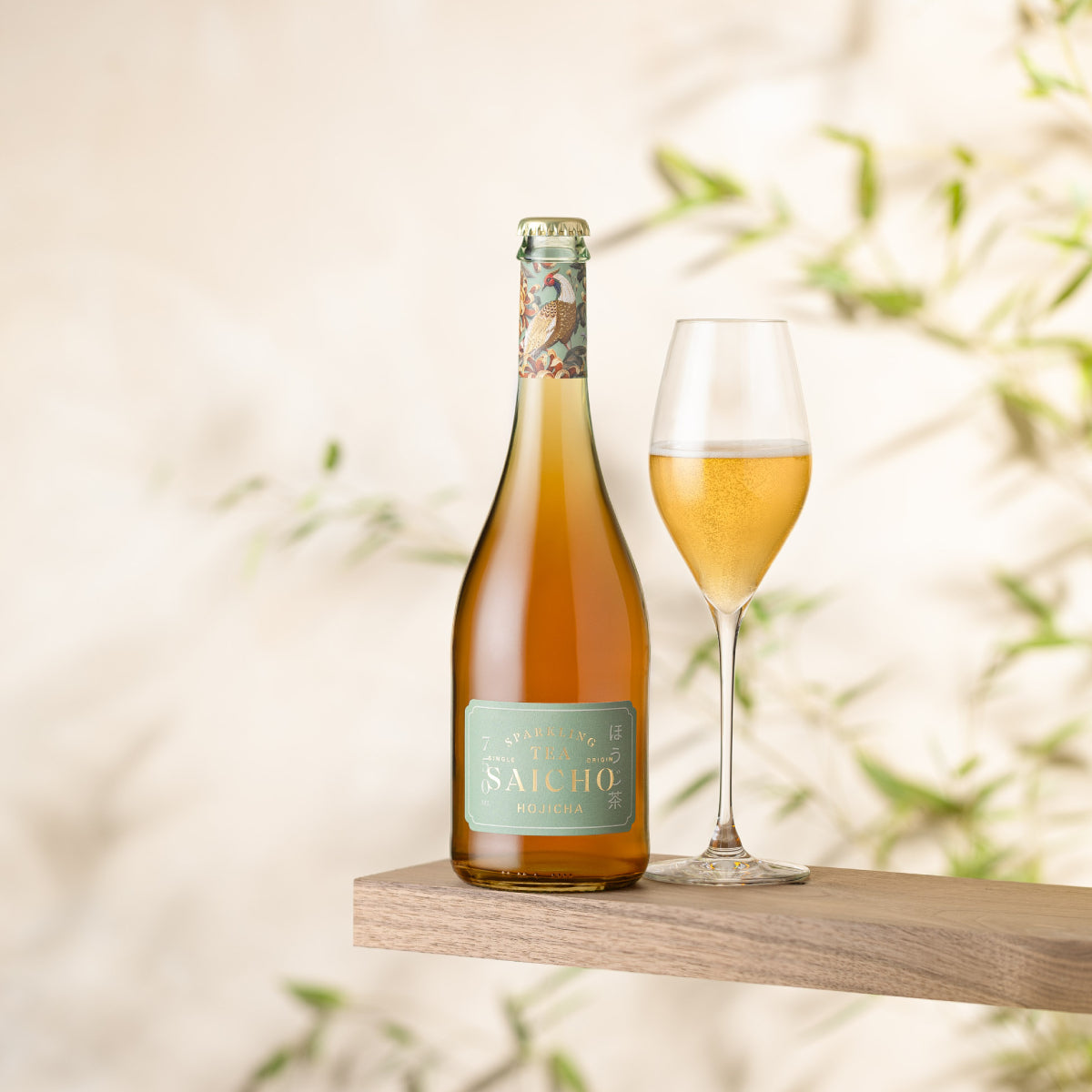 Sparkling hojicha tea bottle with golden drink in a stemmed glass