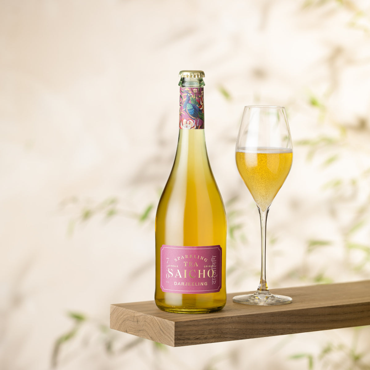 Sparkling Darjeeling tea bottle with filled stemmed glass on wooden stand