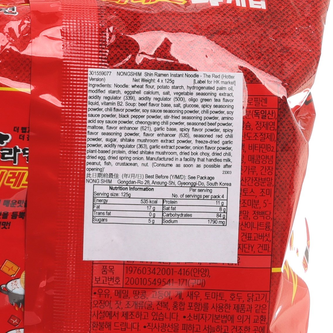 Red instant ramen noodle packet close-up with nutrition facts, ingredients text, and barcode label