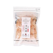 Dried honkarebushi bonito flakes in clear sealed pouch, orange-brown shredded pieces visible