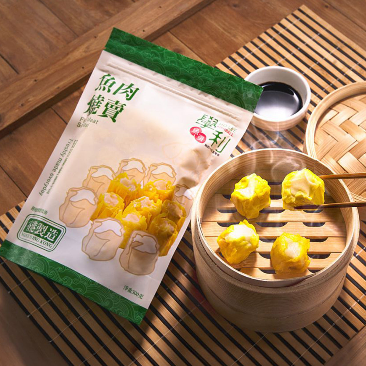 Fish siu mai pouch beside bamboo steamer holding golden siu mai dumplings