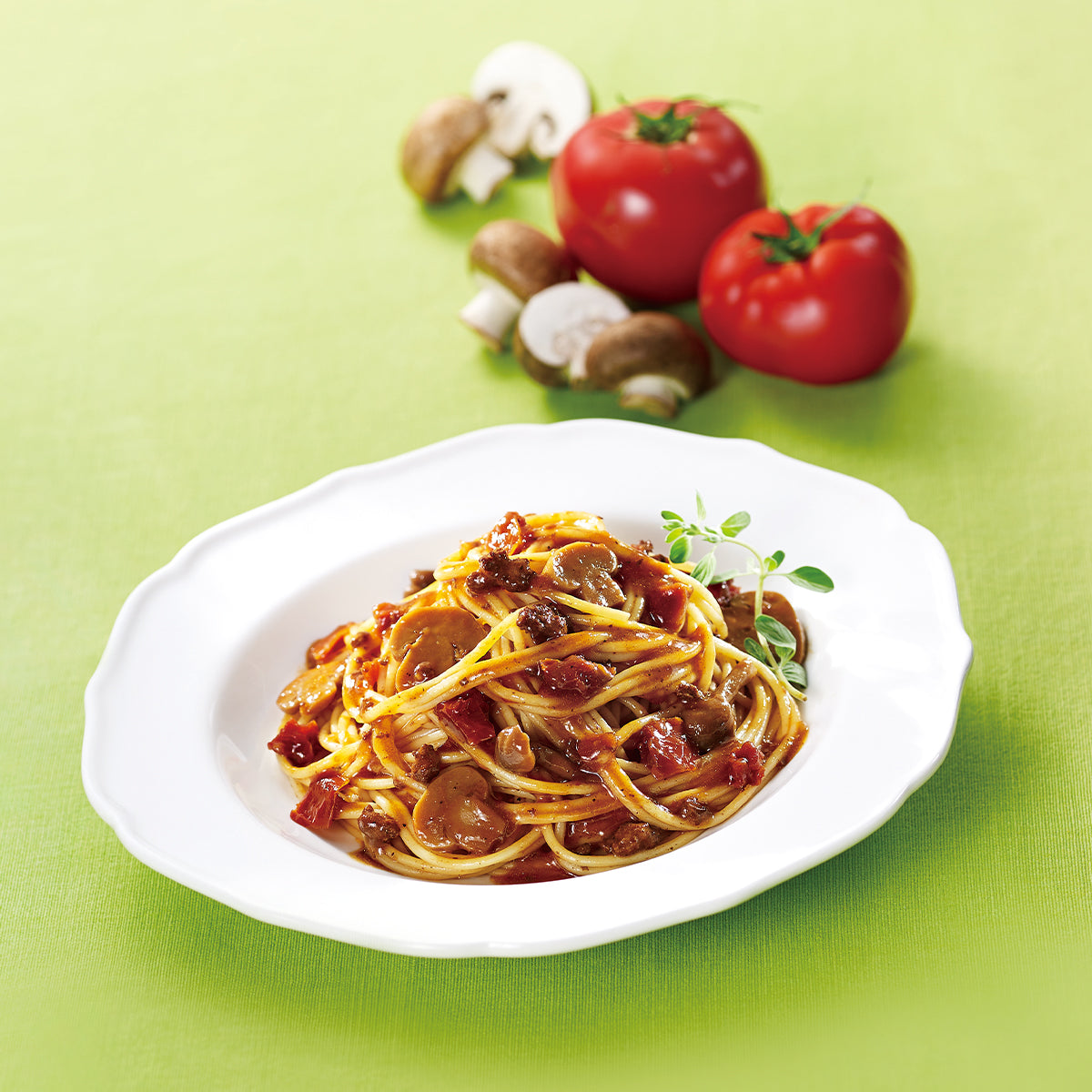Bolognese pasta sauce serving on white plate with spaghetti and herb garnish