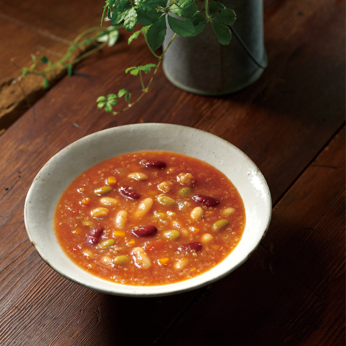 Bowl of red minestrone soup with beans and grains